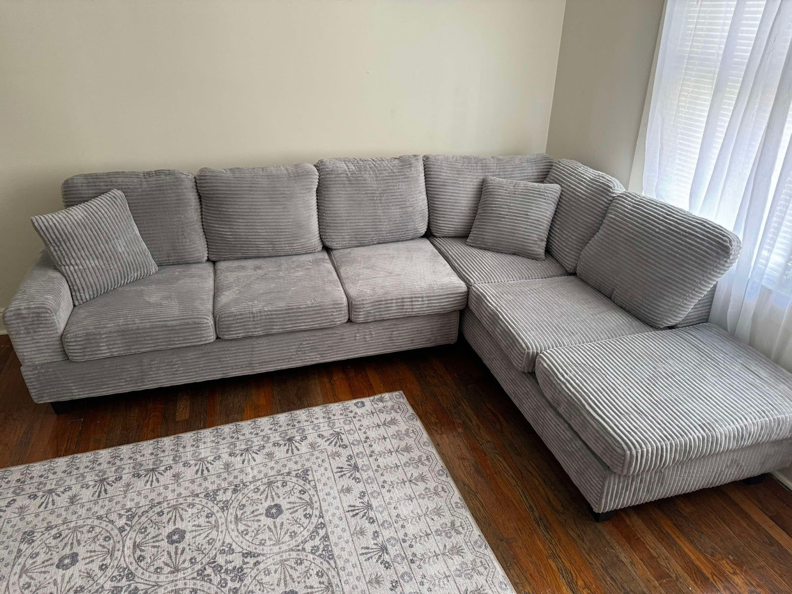 Grey corduroy reversible sectional with drop down cup holders and optional storage ottoman
