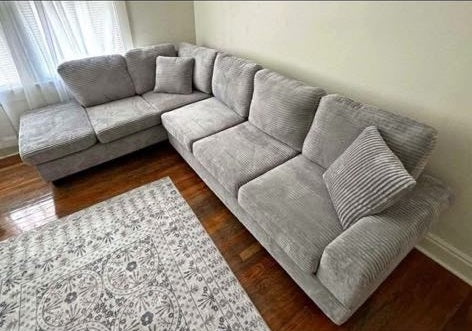 Grey corduroy reversible sectional with drop down cup holders and optional storage ottoman
