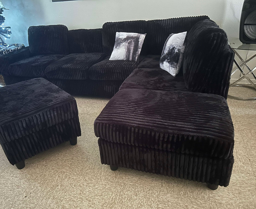 Black corduroy reversible sectional with drop down cup holders and optional storage ottoman