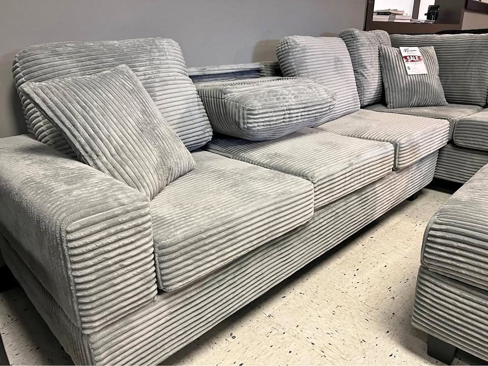 Grey corduroy reversible sectional with drop down cup holders and optional storage ottoman